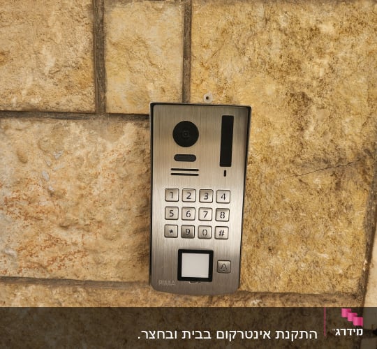 אינטרקום מותקן על קיר אבן חיצוני